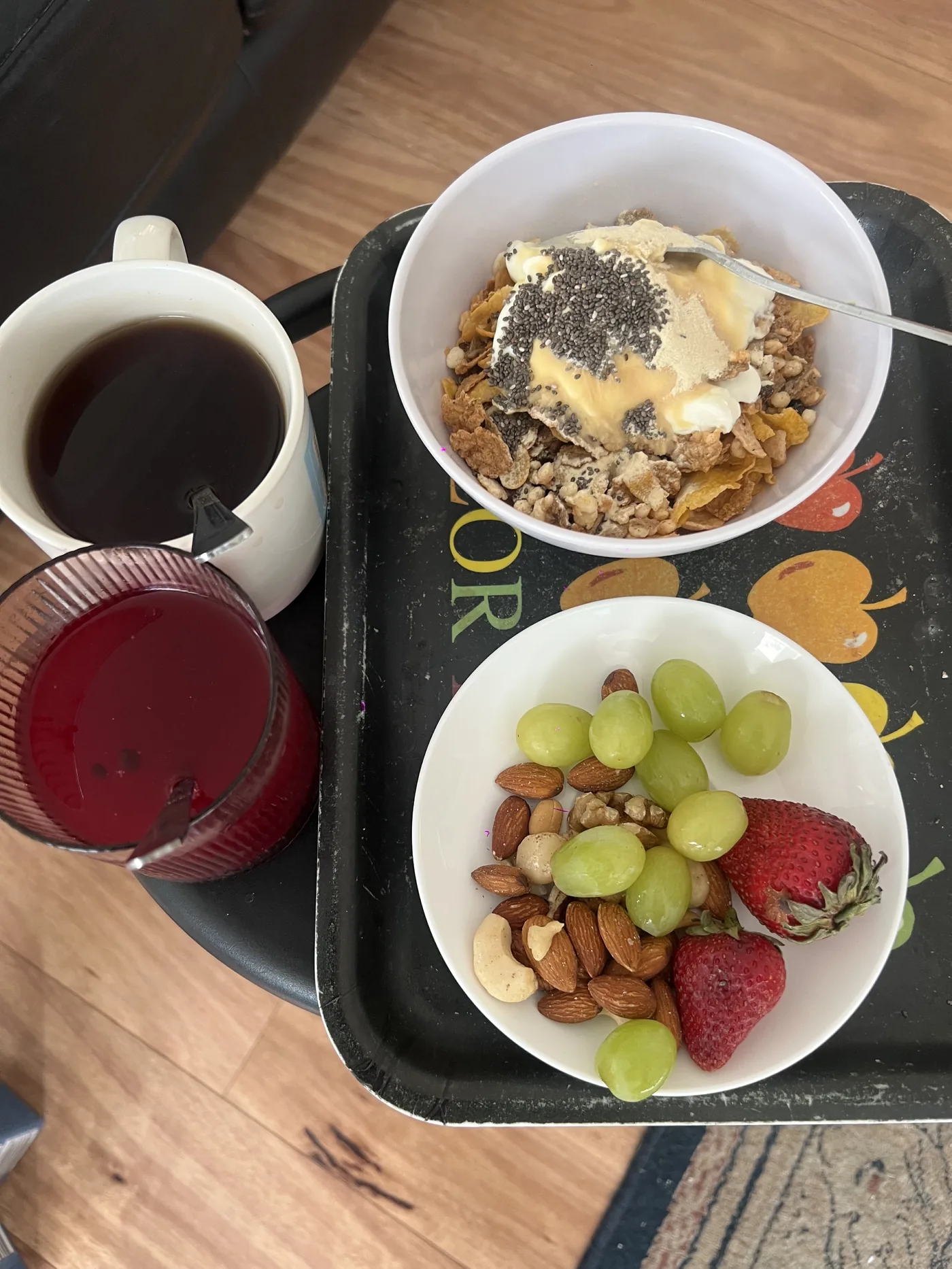 Breakfast tray with cereal bowl, grapes, nuts and hot drink