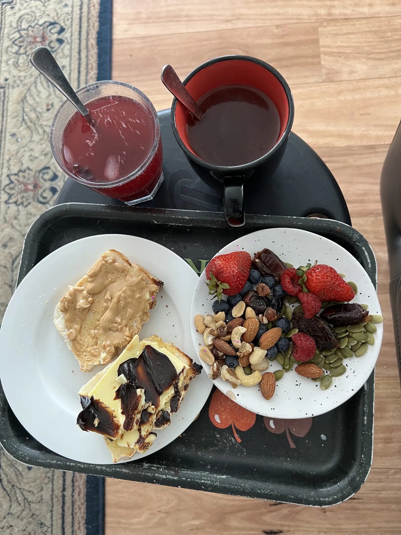 Breakfast tray with toast, berries, nuts and drinks